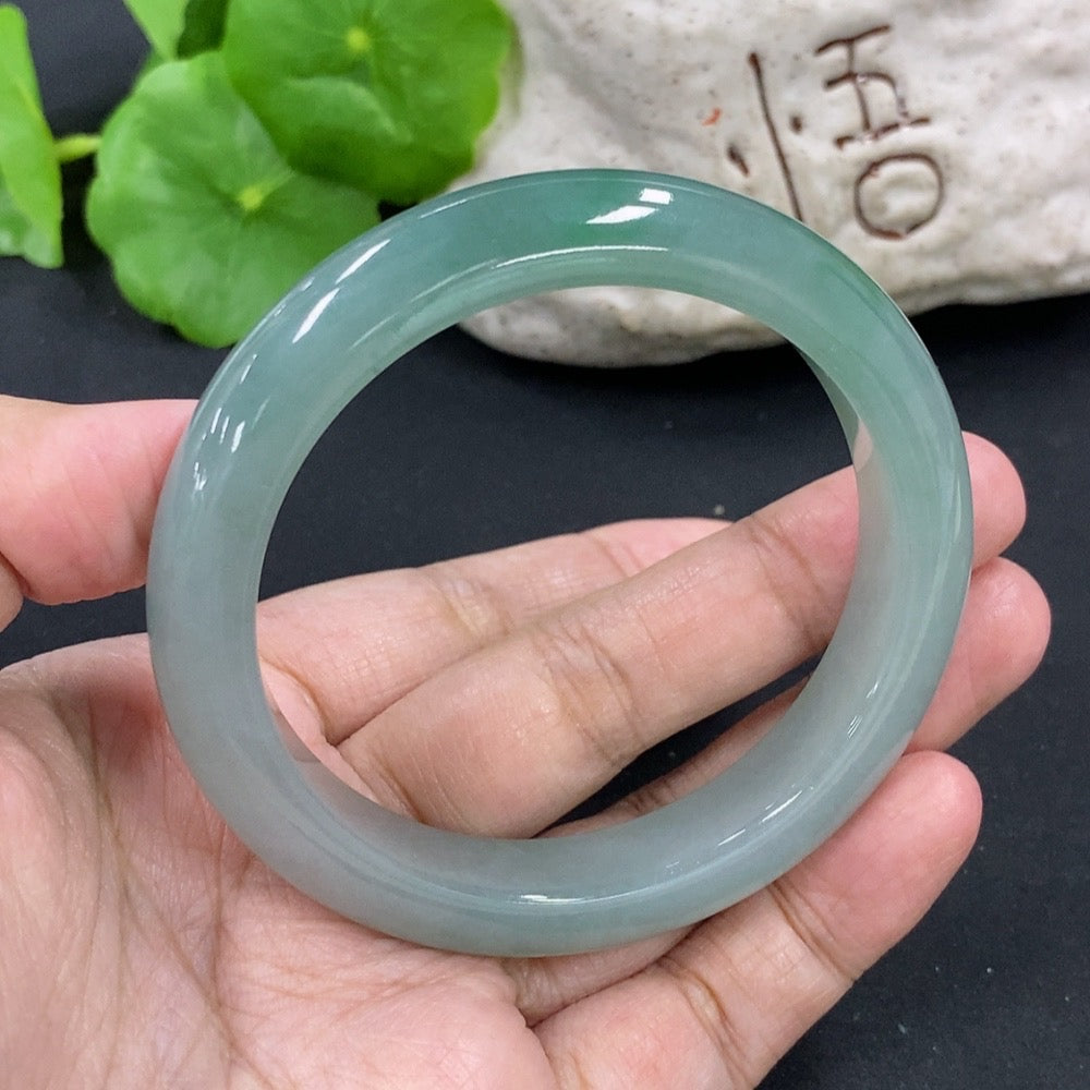 HKHQ jadeite round bangle in size 55.5 with 53.26g, showcasing smooth, polished green jadeite bracelet on a neutral background.