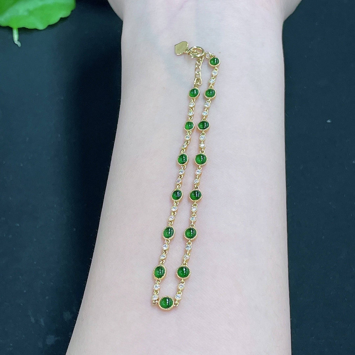 Elegant jadeite cabochon bracelet with 18k gold inlay and diamond accents, showcasing intricate craftsmanship and natural green jade.