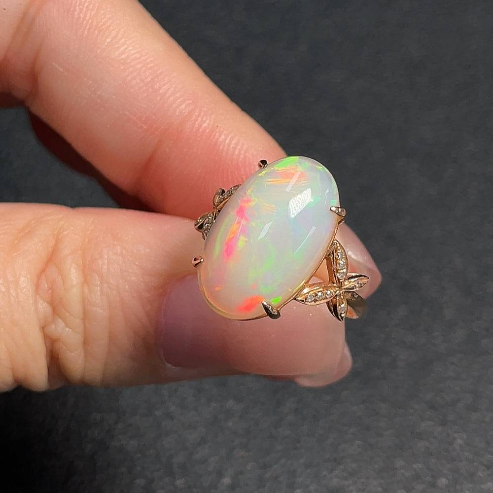 Huiliu gemstone opal ring with diamond accents, 73% content, featuring a polished opal and small sparkling diamonds.