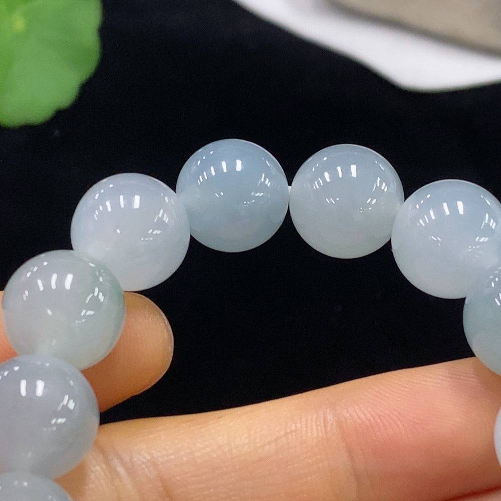 Jadeite bracelet with 12.1mm beads, weighing approximately 51.08g, featuring smooth, polished jade stones on a string.