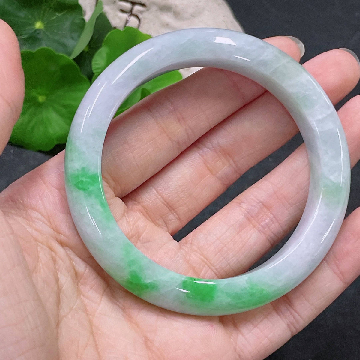 Huiliu certified jadeite round bangle showcasing smooth, polished green jade with a glossy finish and intricate craftsmanship.