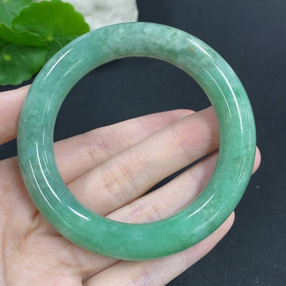 Huiliu Certified jadeite round bangle showcasing smooth, polished jade surface with subtle natural green hues and elegant design.