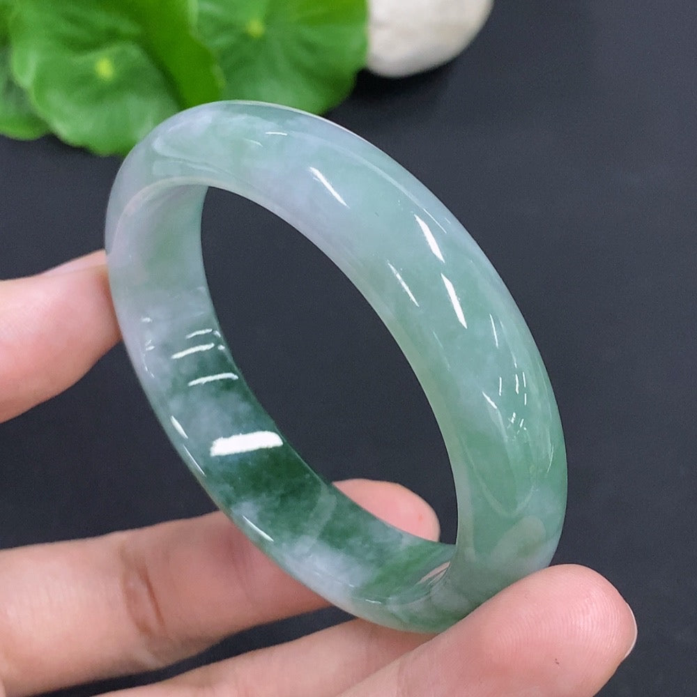 HKHQ jadeite oval bangle in size 53, weighs 38.1g, featuring a smooth, polished green jadeite bracelet on a white background.
