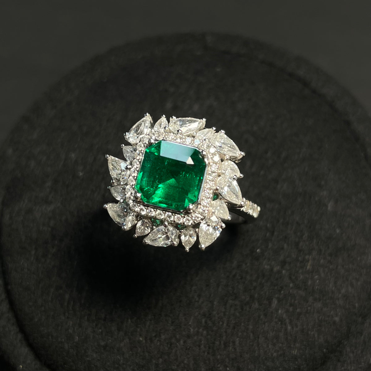 Emerald ring with diamond accents, clarity enhanced, set in 18K gold, featuring a detailed close-up of the jewelry design.