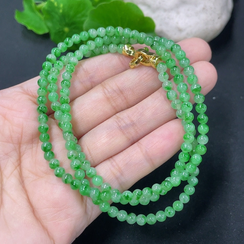 HKHQ jadeite bead necklace featuring non-gold mineral components, showcasing smooth, round jadeite beads on a natural string.