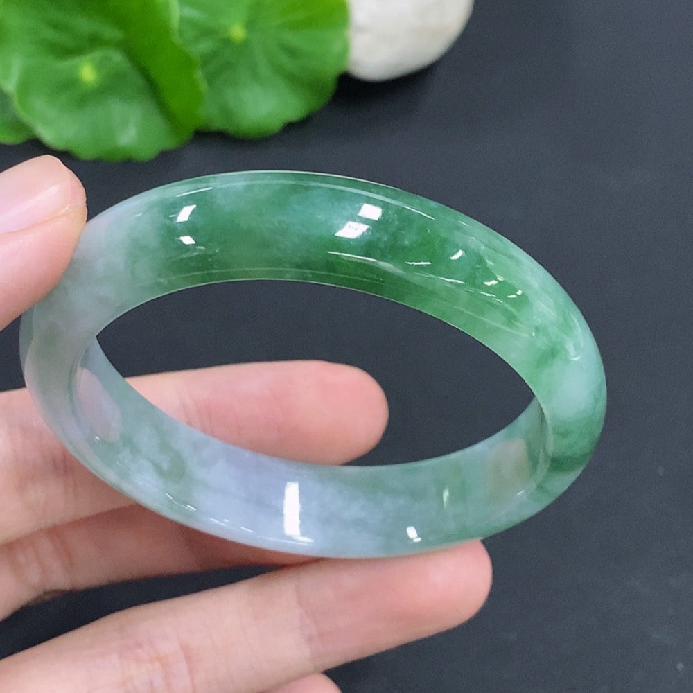 HKHQ Jadeite oval bangle in size 53, weighing 38.1g, showcasing smooth, polished green jadeite bracelet on a plain background.