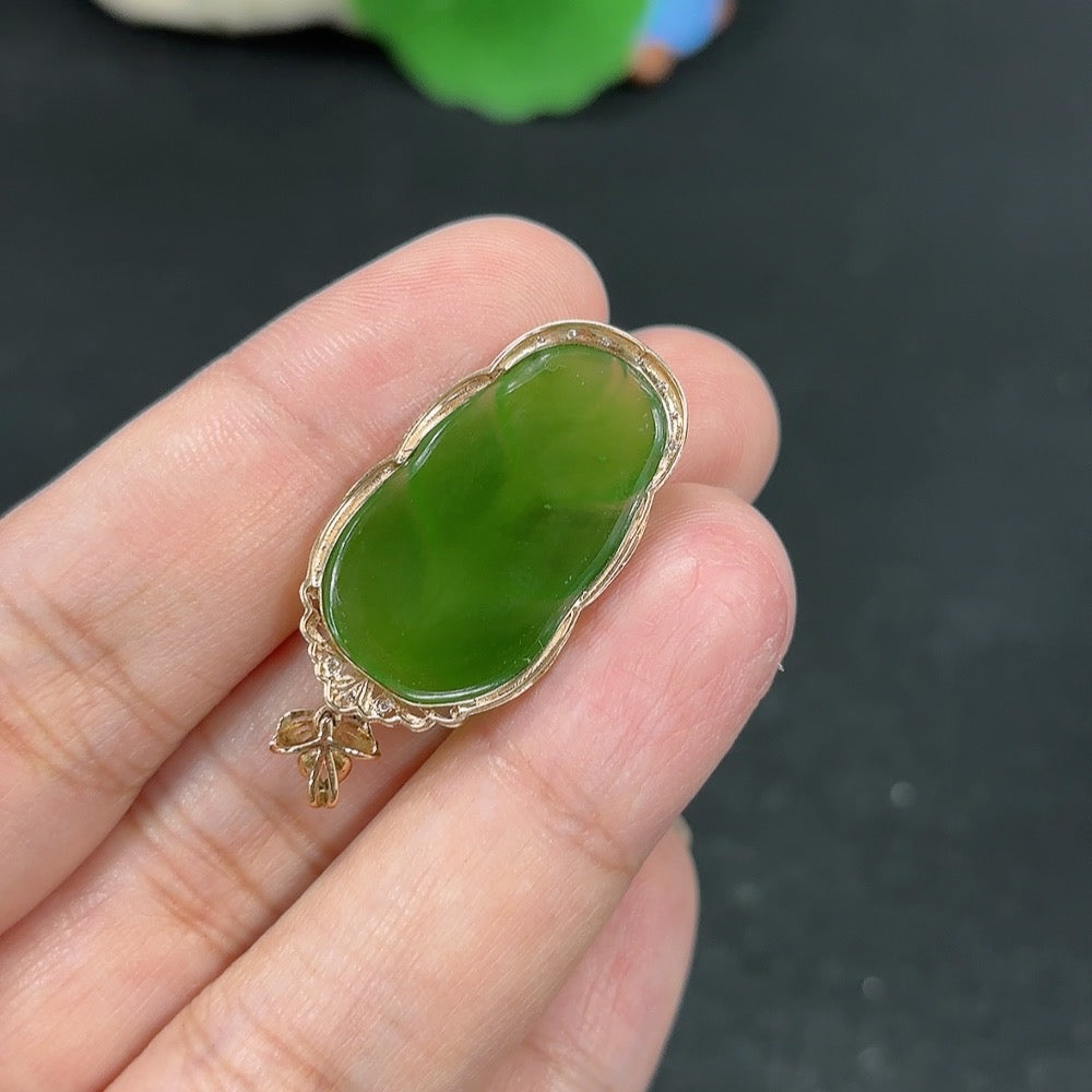 Green Hetian Jade pendant with intricate inlay design, hanging on a delicate necklace from HKHQ, showcasing craftsmanship and elegance.