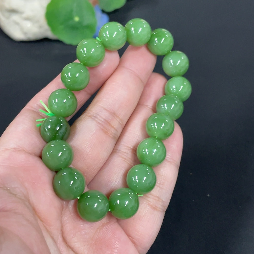 Huiliu Hetian Jade bracelet with 11.8mm smooth jade beads, certified Huiliu HQ, showcasing a polished and elegant jewelry piece.