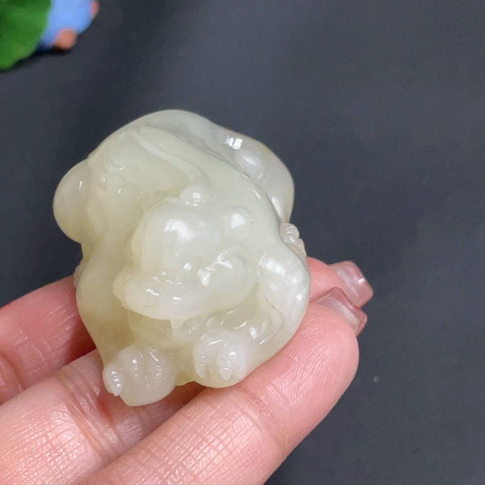 Huiliu certified Hetian jade pendant featuring an auspicious beast carving, natural skin color, and intricate jade craftsmanship.
