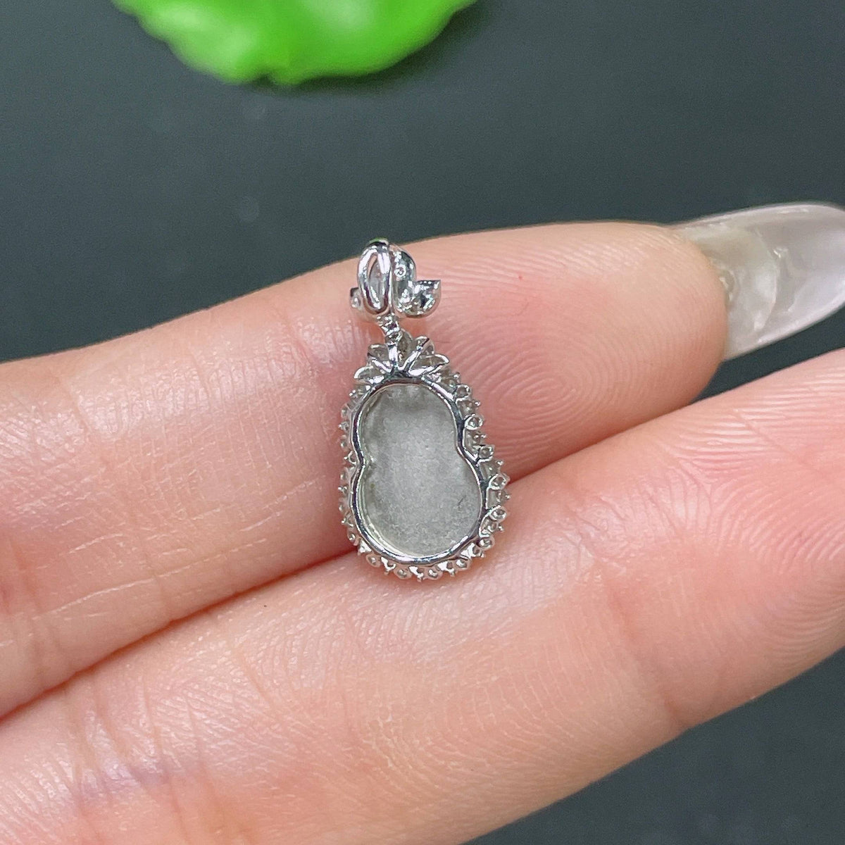Jadeite gourd pendant inlaid with diamonds and 18k gold, featuring intricate craftsmanship and a smooth, polished surface.