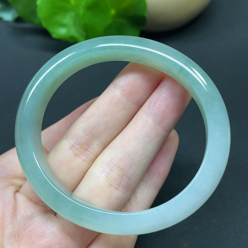 HKHQ jadeite oval bangle in size 55.6 with a polished surface, weighing 35.37g, showcasing its elegant and smooth design.