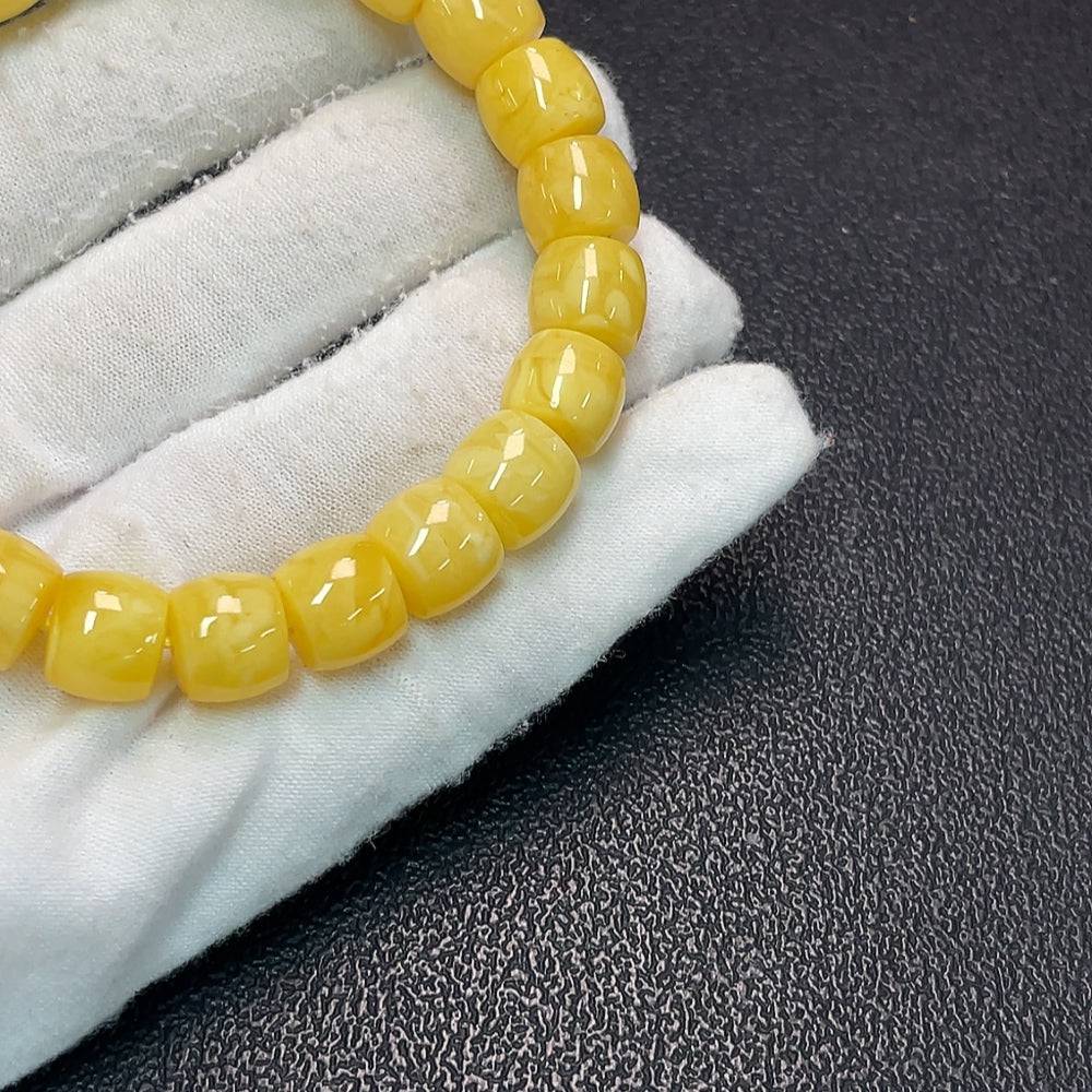 Amber Beeswax Bracelet by HUILIU HQ, 16.42g, with 10.6mm amber beads, natural warm amber color, close-up of bracelet on white background
