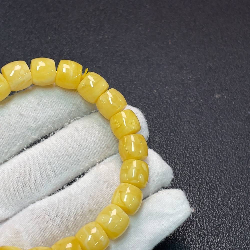 Amber beeswax bracelet by HUILIU HQ with 10.6mm beads, weighing approximately 16.42g, showcasing natural amber texture and warm color.
