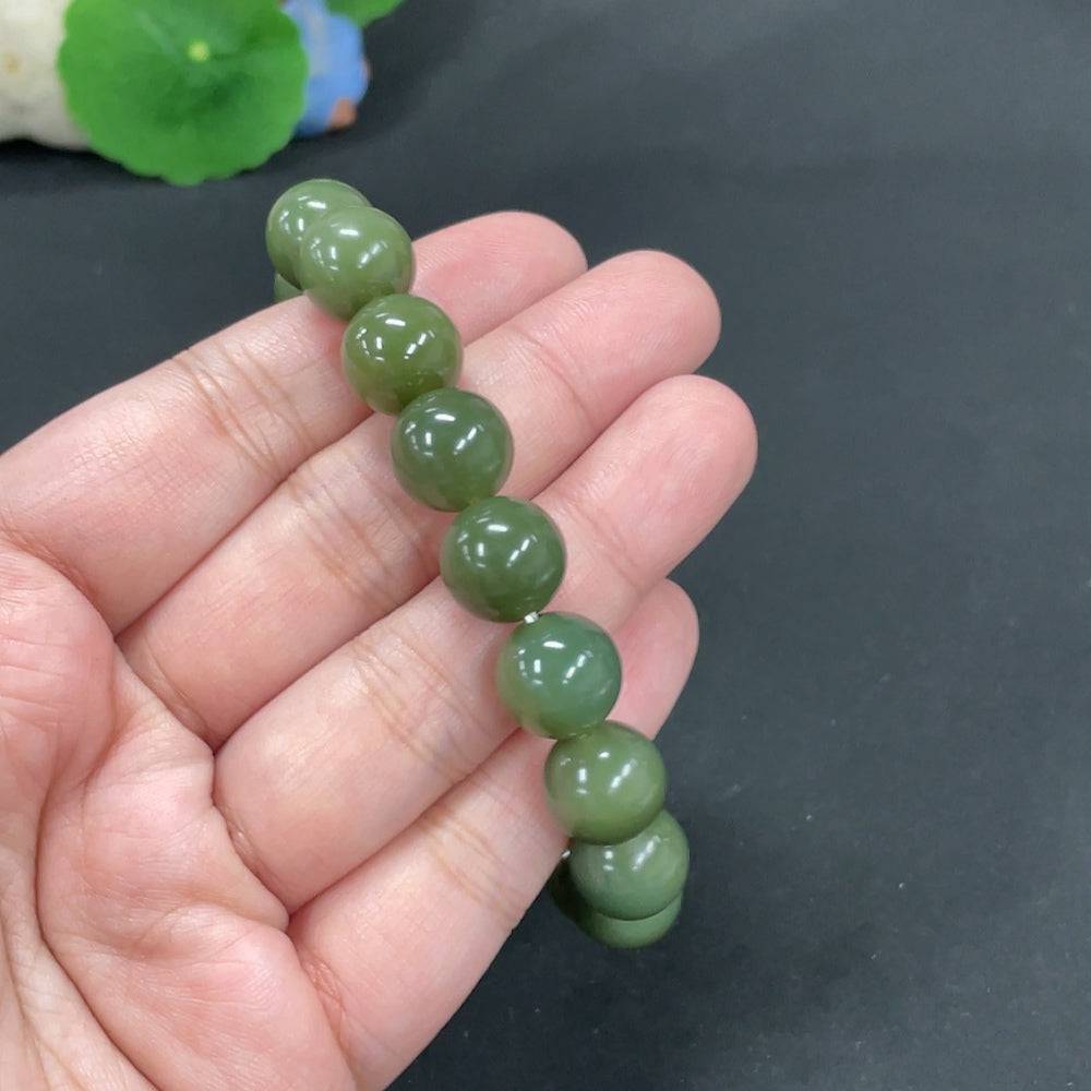 Huiliu certified Hetian jade bracelet with 12mm round jade beads, showcasing smooth, polished green jade on a neutral background.