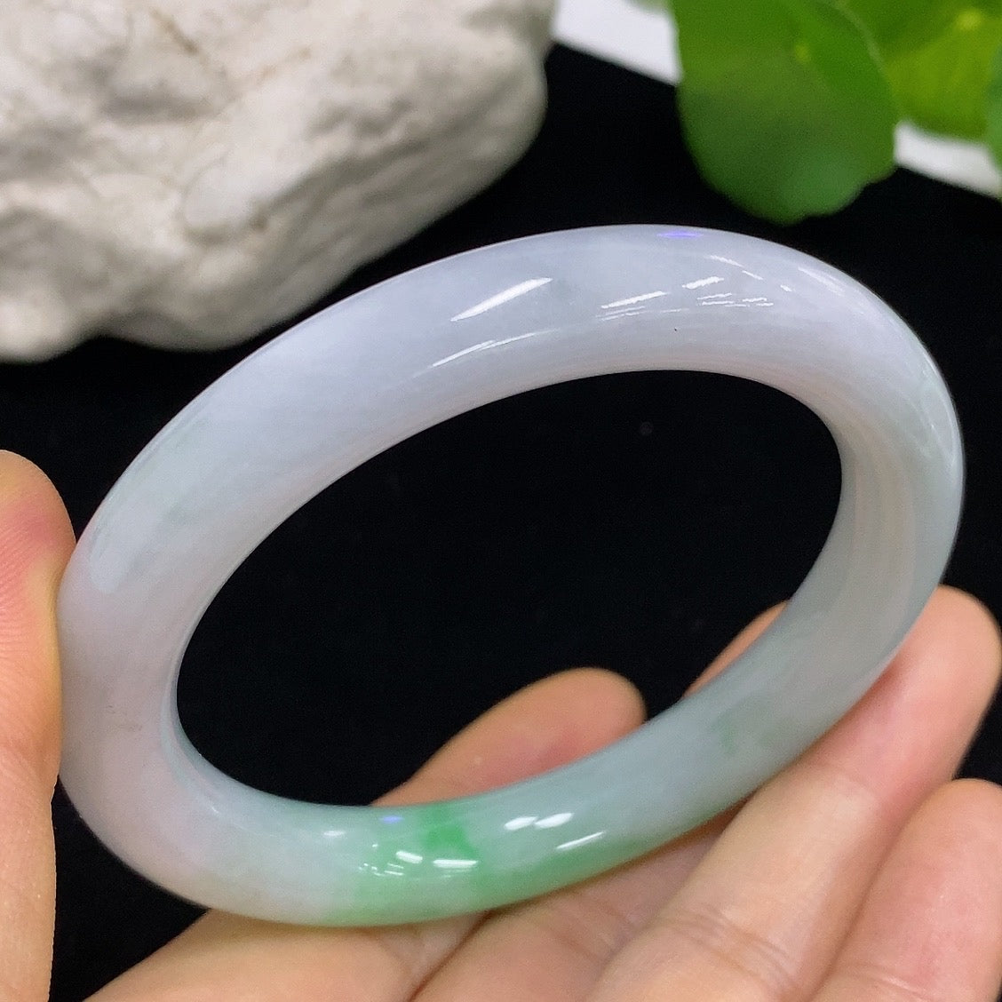 HKHQ jadeite round bangle in size 55, showcasing its smooth, polished surface and vibrant green color on a neutral background.