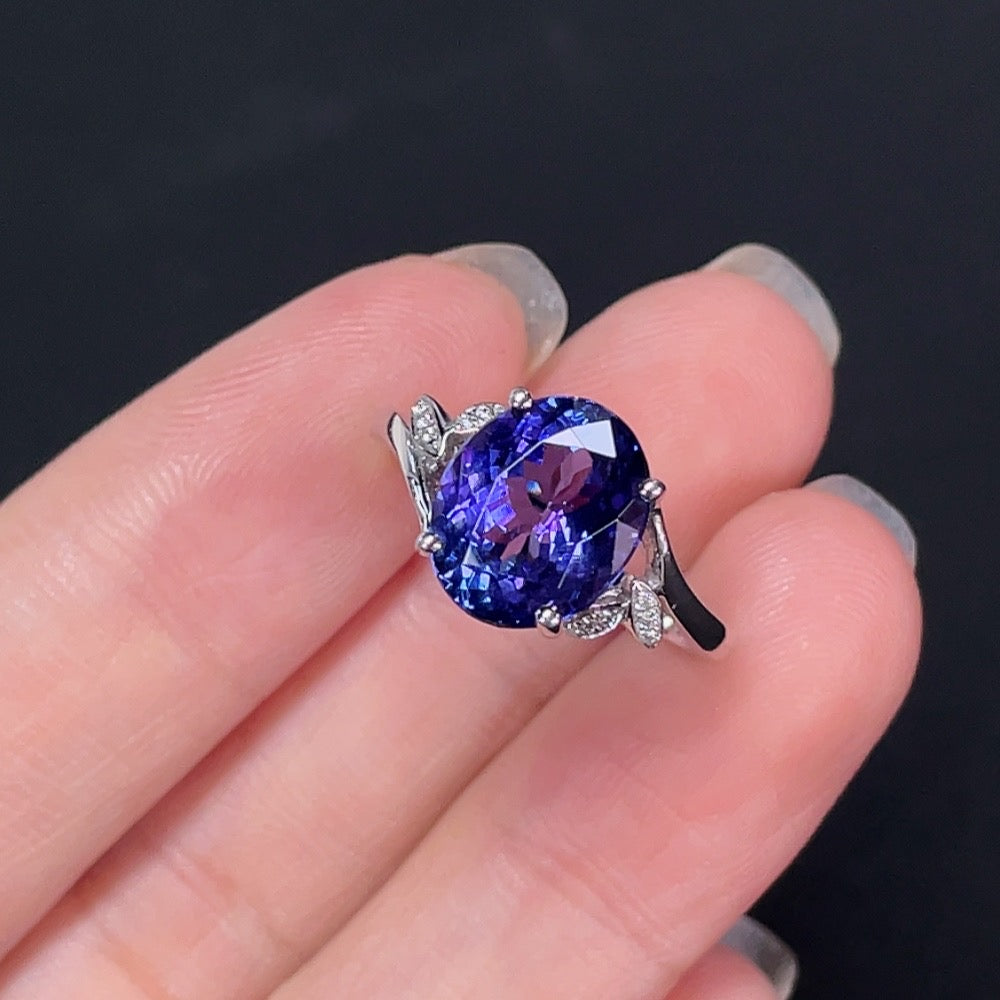 Elegant Tanzanite ring with 18K gold band, featuring a vibrant blue gemstone, styled by HKHQ.