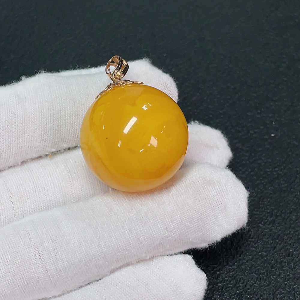 18K amber beeswax pendant from HUILIU HQ, approximately 25mm in size, showcasing warm amber color and intricate natural texture.