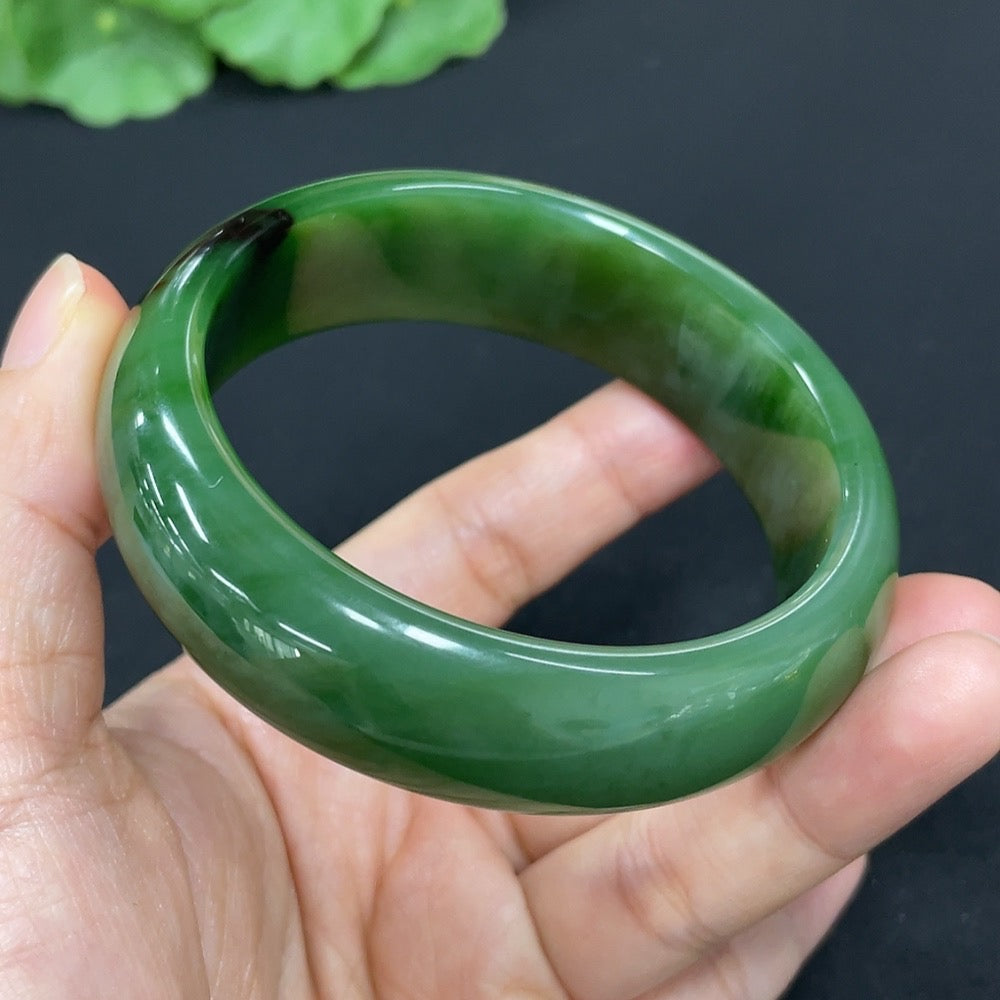 Green Hetian Jade round bangle bracelet by HKHQ, showcasing smooth polished jade with natural green hues and rounded design.