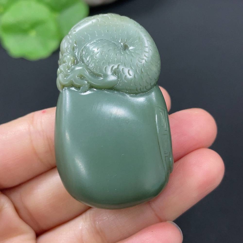 Huiliu certified Hetian jade pendant featuring the God of Wealth, intricately carved with a smooth, polished surface.
