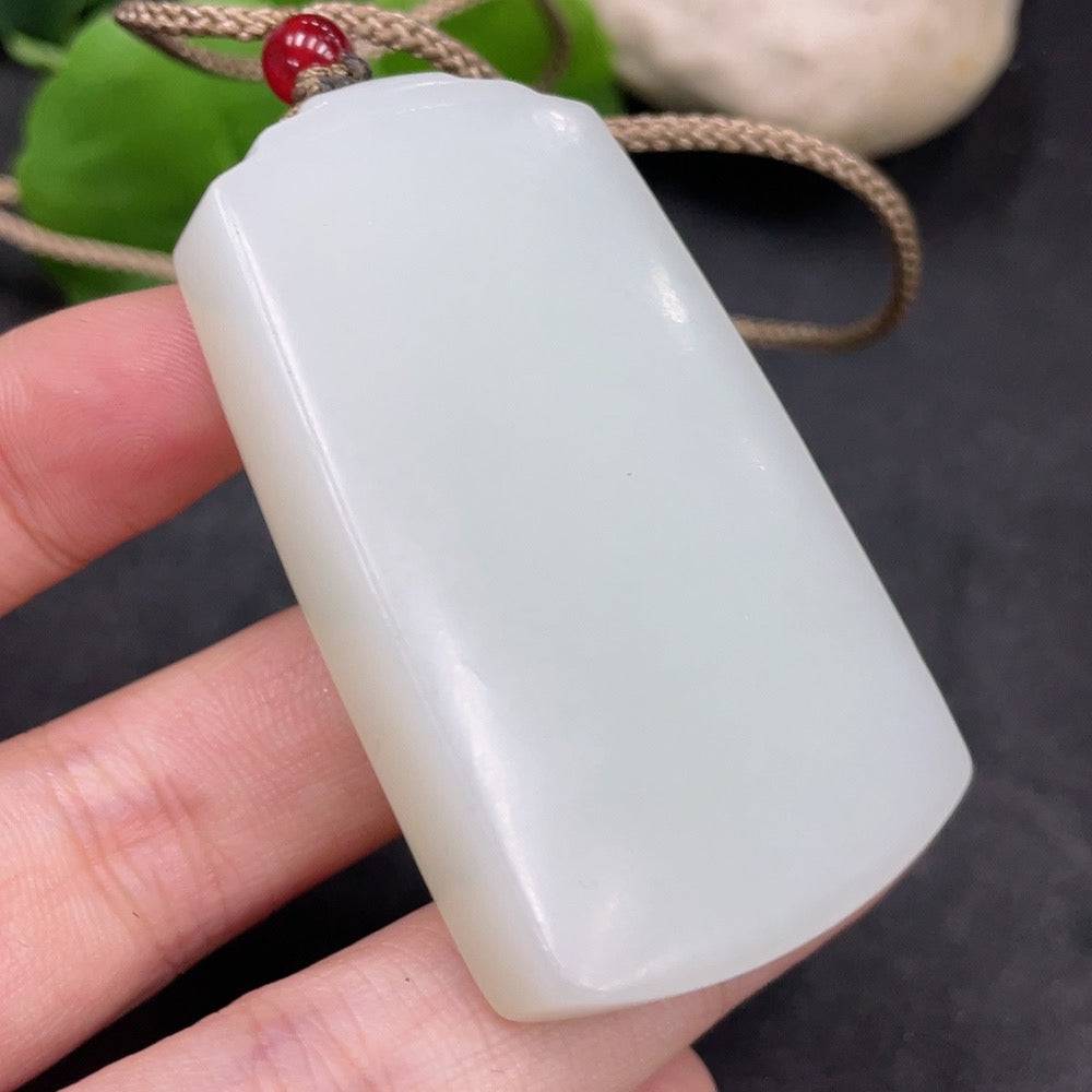 Huiliu certified Hetian jade pendant featuring a plain, smooth jade stone with intricate natural texture and polished finish.