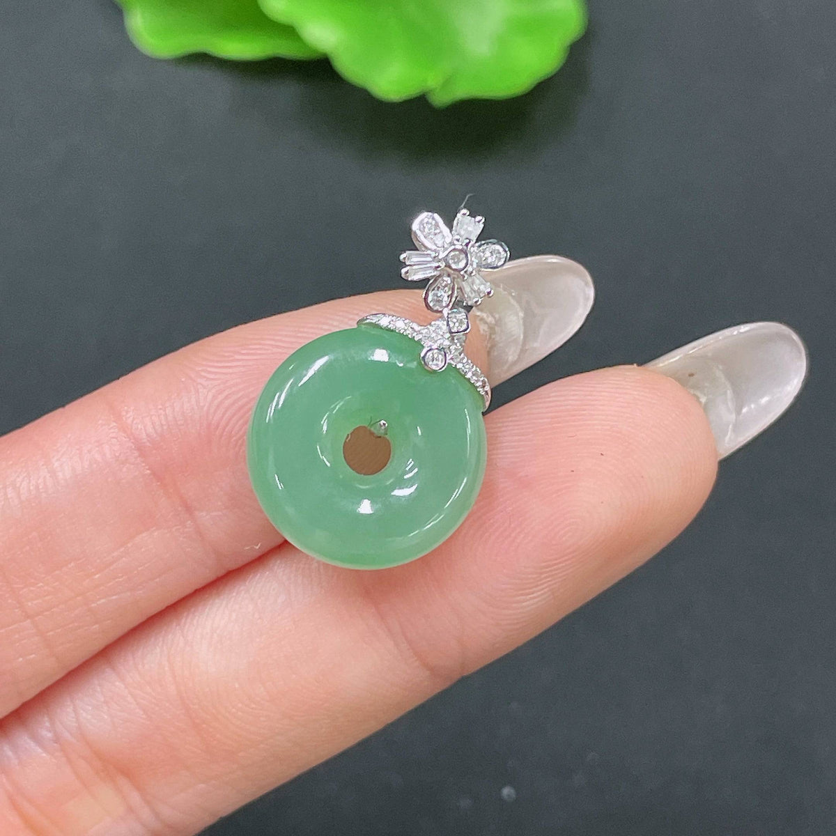 Jadeite pendant featuring a peace knot design with 18k gold inlay and diamond accents, weighing approximately 3.47g.