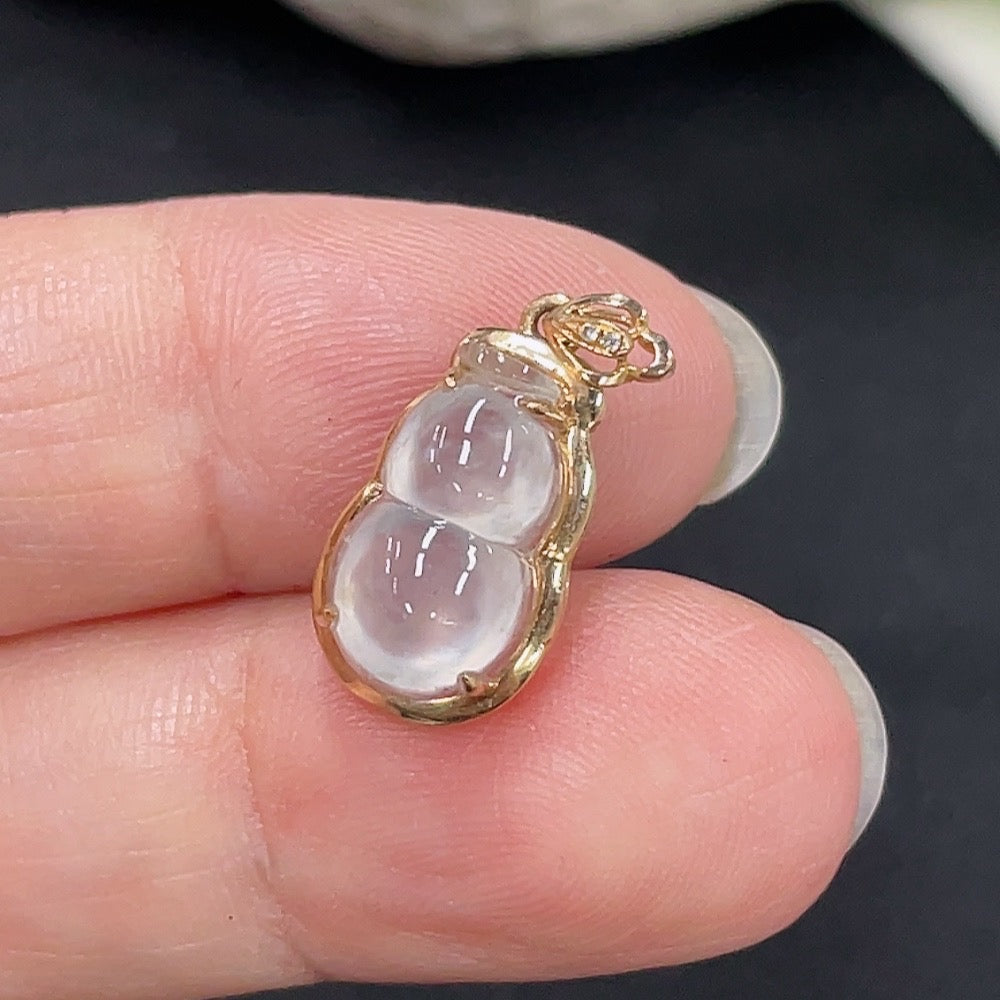 Jadeite gourd pendant with inlaid design in 18K gold, displayed on a white background, showcasing intricate craftsmanship.