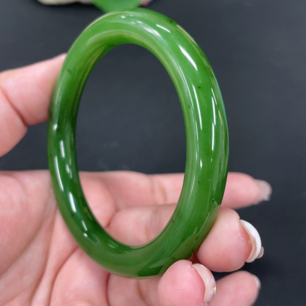 Huiliu Certified Hetian Jade round bangle showcasing smooth, polished green jade with natural variations and a glossy finish.