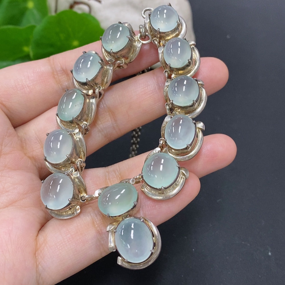 Jadeite cabochon gemstone with non-gold setting, weighing approximately 61.2 grams, displayed on a neutral background.