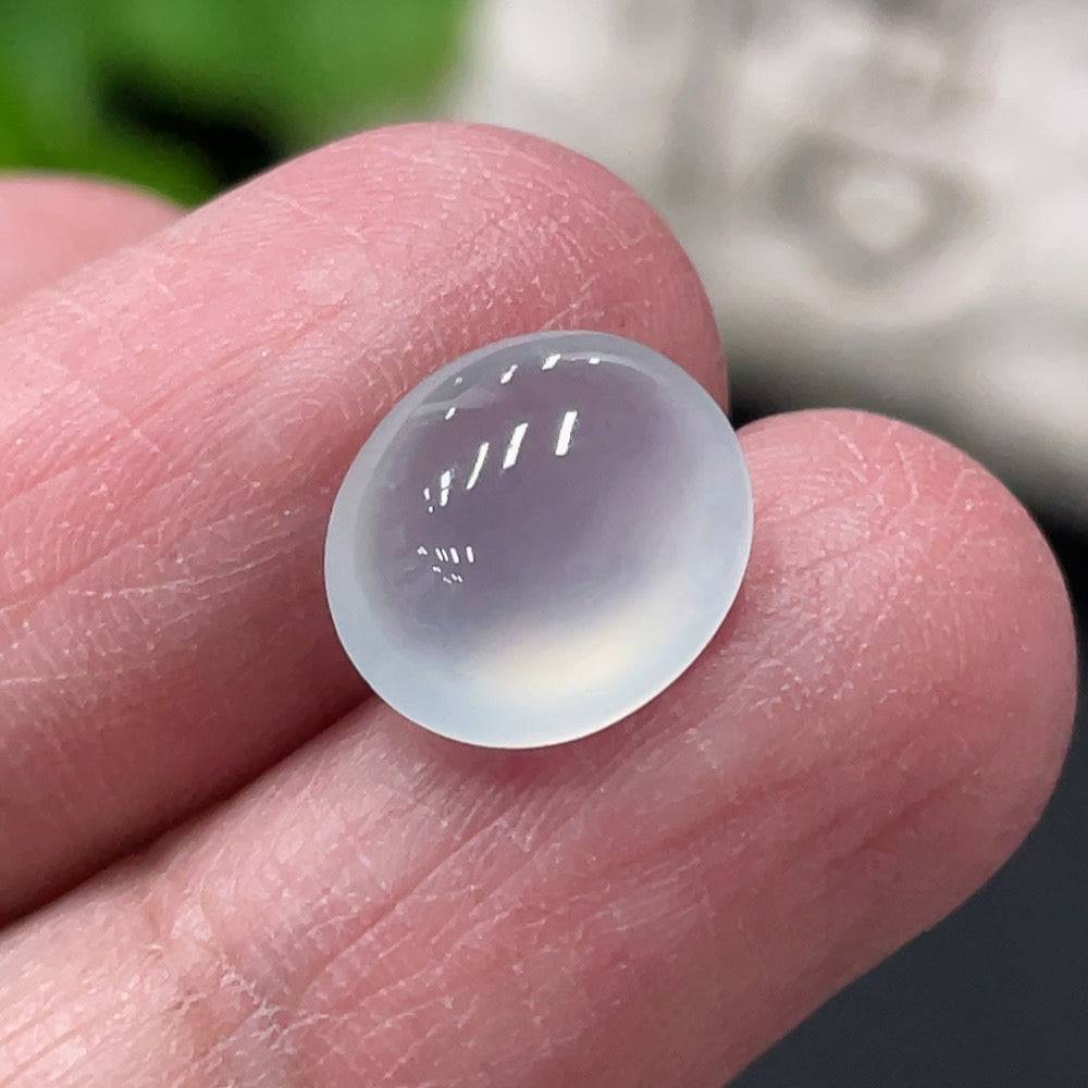 Jadeite cabochon from HUILIU HQ, weighing approximately 0.73g, with smooth polished surface and vibrant green color.