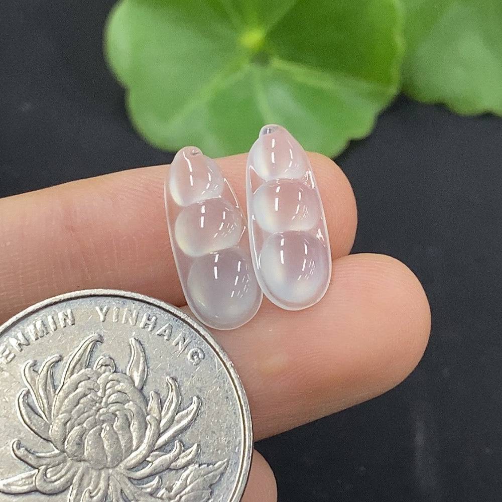 Jadeite auspicious bean inlay piece by HUILIU HQ, showcasing intricate jade craftsmanship on a smooth polished surface.
