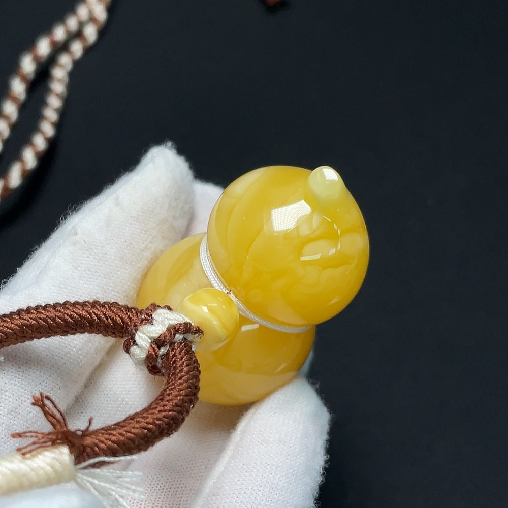 Amber beeswax pendant necklace by HKHQ, featuring a smooth, natural amber bead on a delicate chain.