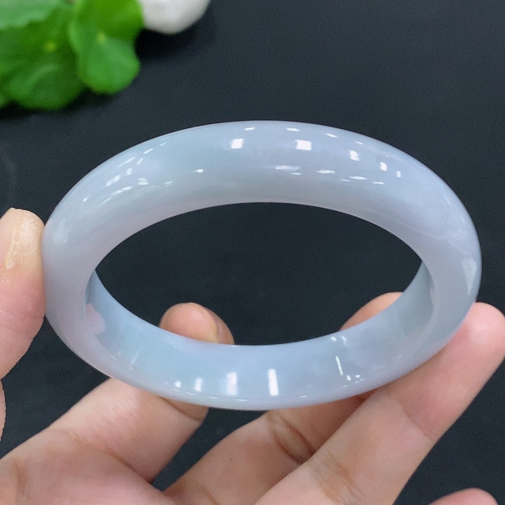 Huiliu certified jadeite round bangle in vibrant green, showcasing smooth, polished surface and traditional craftsmanship.