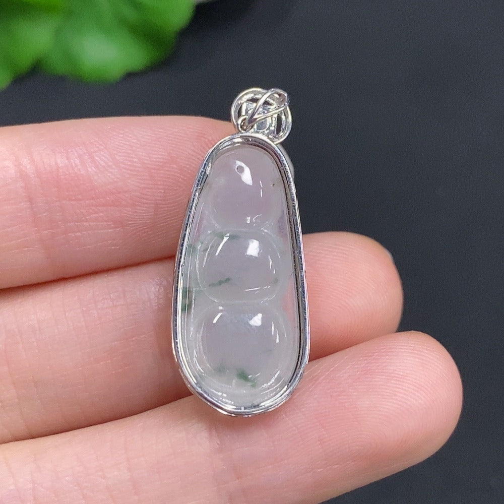 Jadeite lucky bean pendant with diamond accents in 18k gold, shown on a jewelry display, crafted by HUILIU HQ.