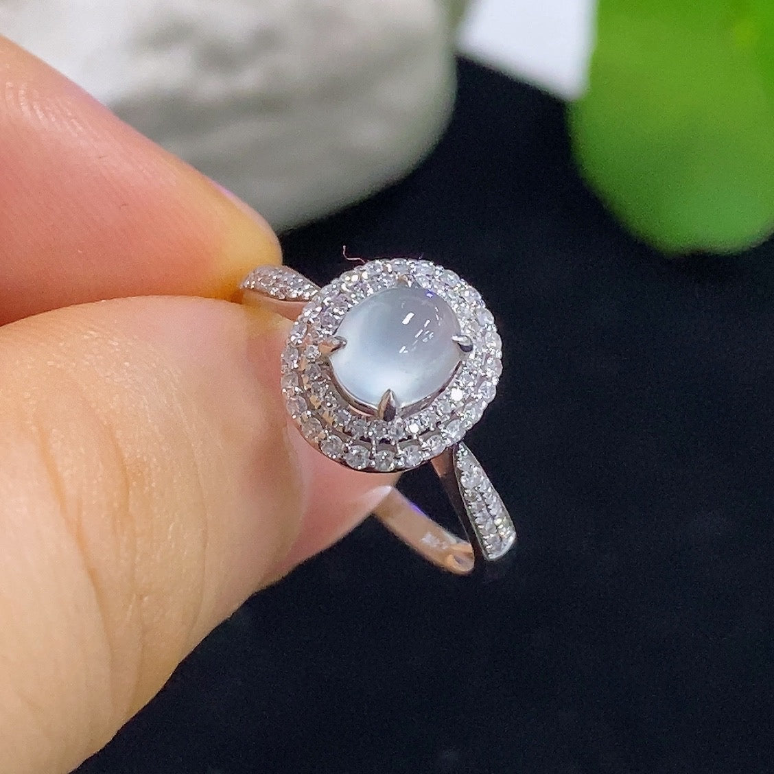 Jadeite cabochon solitaire ring with 18K gold band and diamond accents, featuring a polished green jadeite stone.