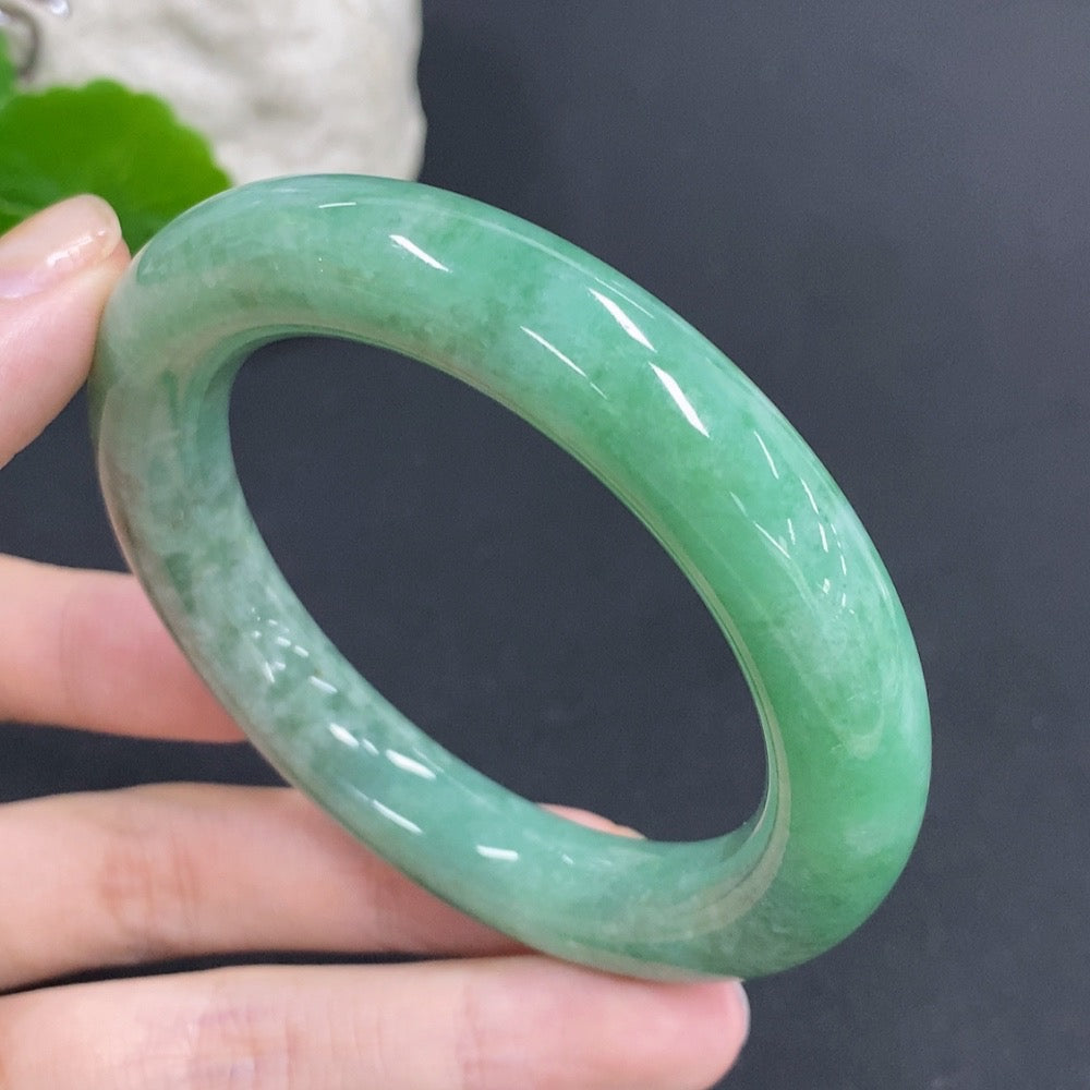 Huiliu Certified Jadeite round bangle with smooth polished surface, showcasing the vibrant green hue of authentic jade jewelry.