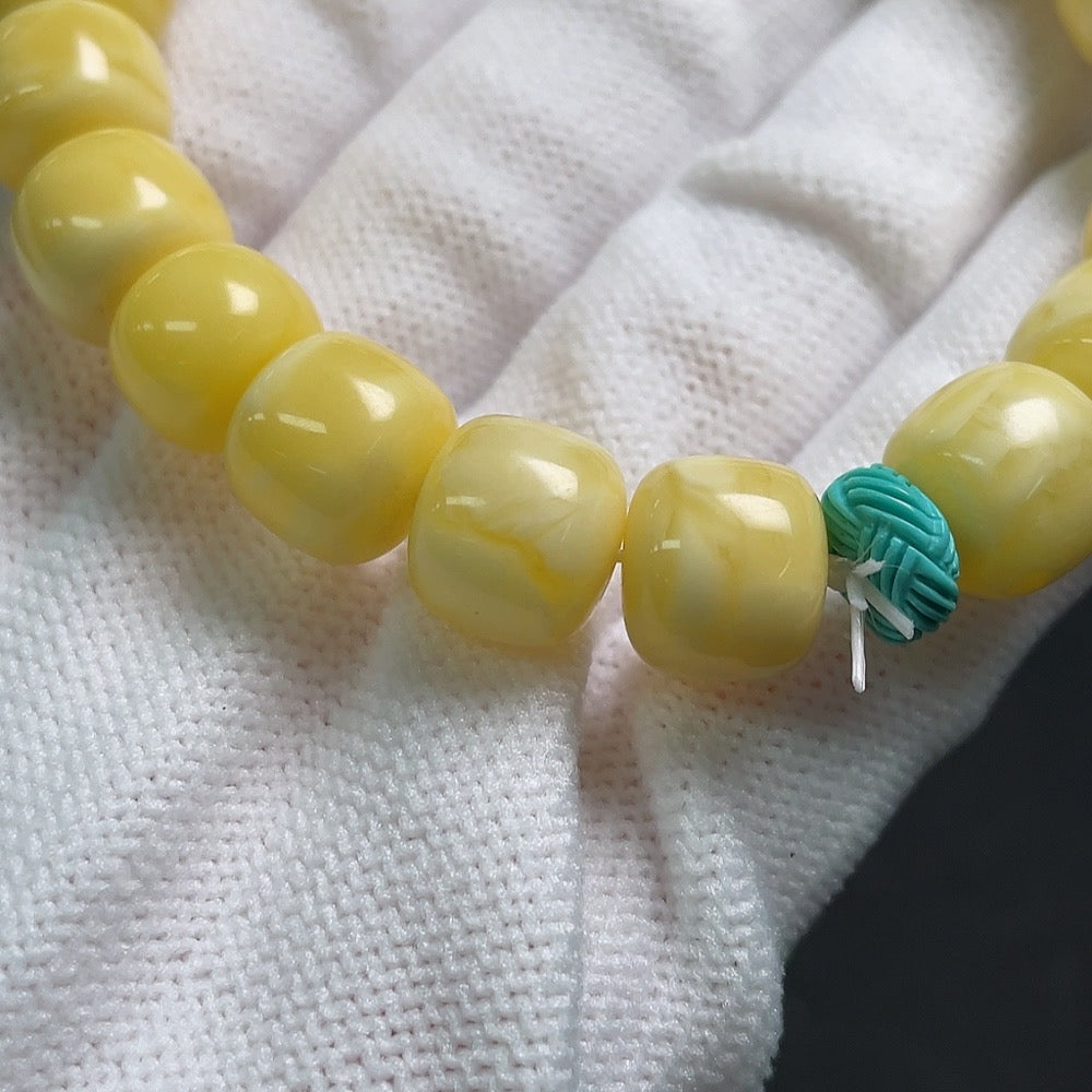Amber beeswax bracelet with visible repairs, possibly turquoise accents, from HUILIU HQ, weighs 14.1g with 10.4mm beads.