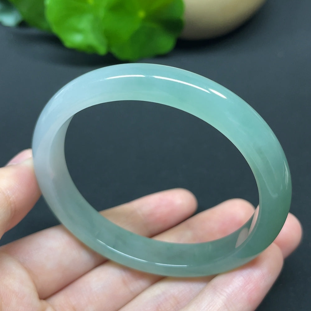 HKHQ Jadeite oval bangle in size 55.6 with a polished finish, weighing 35.37g, showcasing smooth oval shape and vibrant green color.