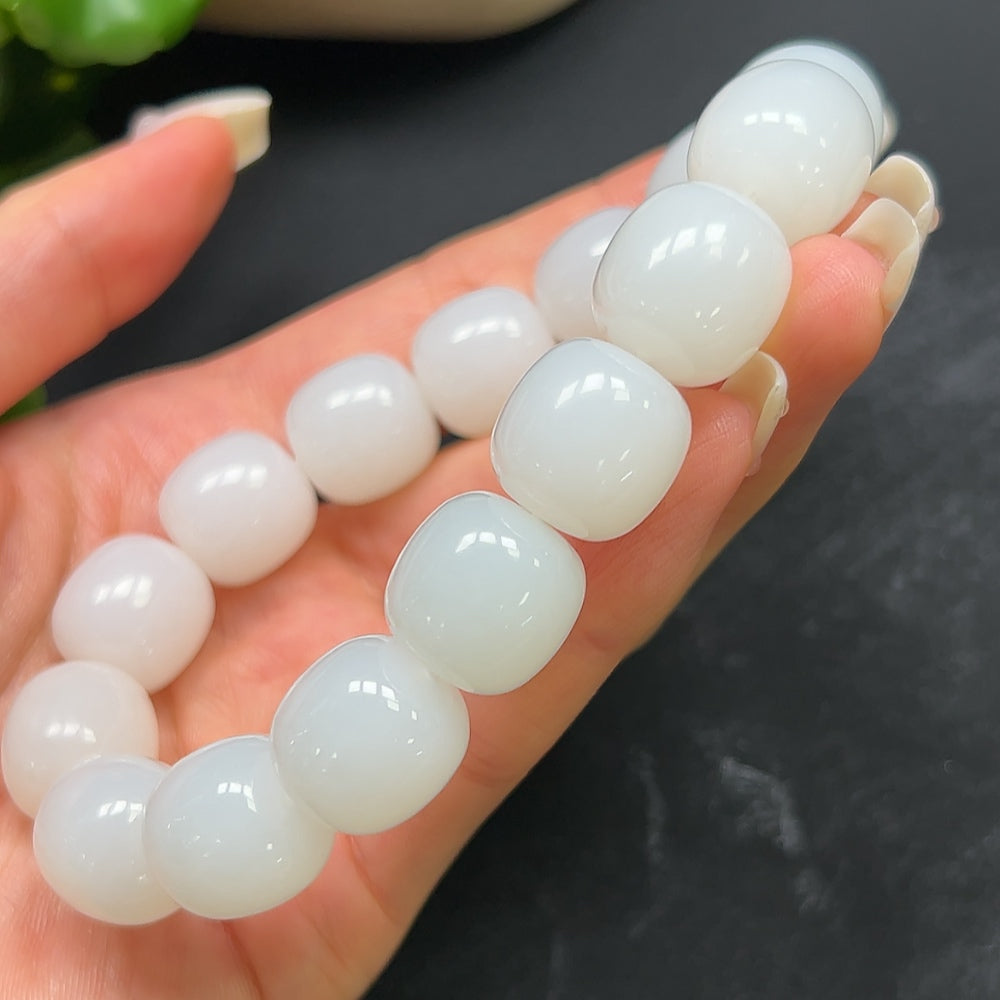 HKHQ Hetian Jade bracelet weighing 87.51g, featuring smooth, polished jade beads on a string, displayed close-up.