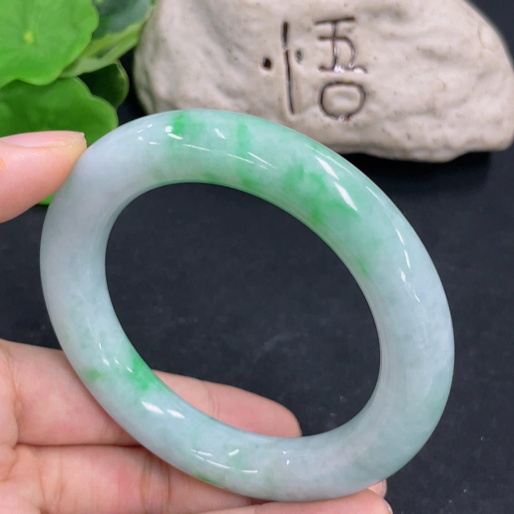 Round jadeite bangle from HKHQ, weighing 80.5g and size 56.2, showcasing smooth, polished green jadeite surface.