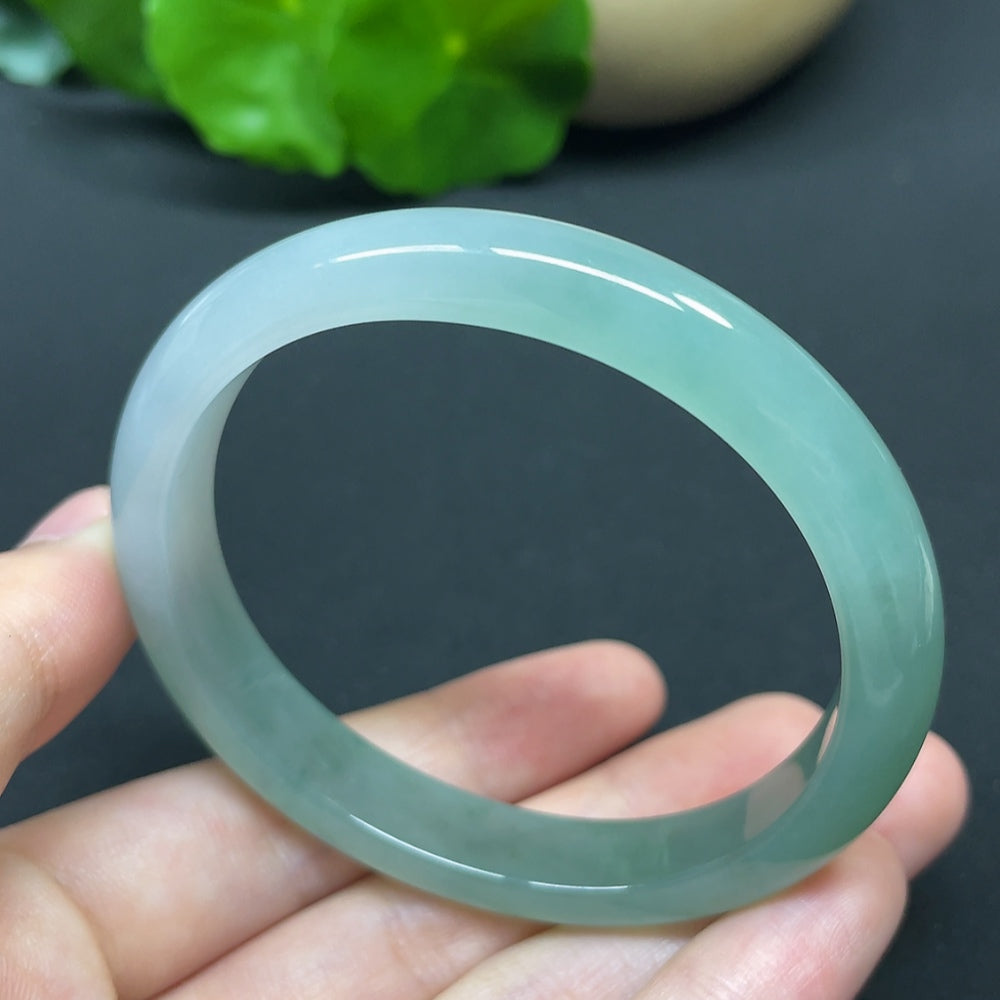 HKHQ jadeite oval bangle in size 55.6, weighing 35.37g, showcasing smooth, polished green jadeite bracelet on a neutral background.