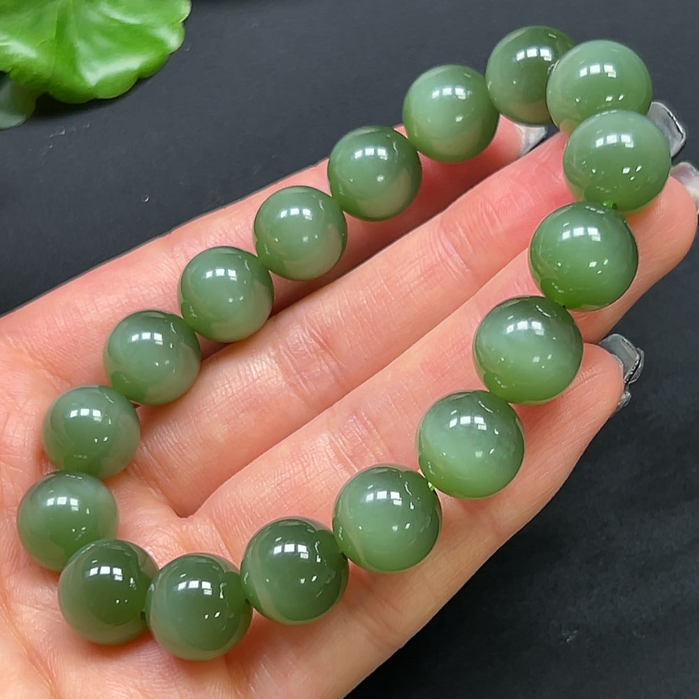 HKHQ Hetian jade bracelet with 11.8mm round beads, showcasing smooth, polished green jade stones on a delicate bracelet.