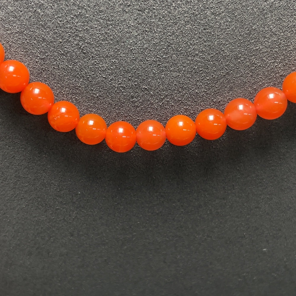 Red agate bead strand necklace with 18K gold accents, featuring tourmaline and pearl elements, displayed against a neutral background.