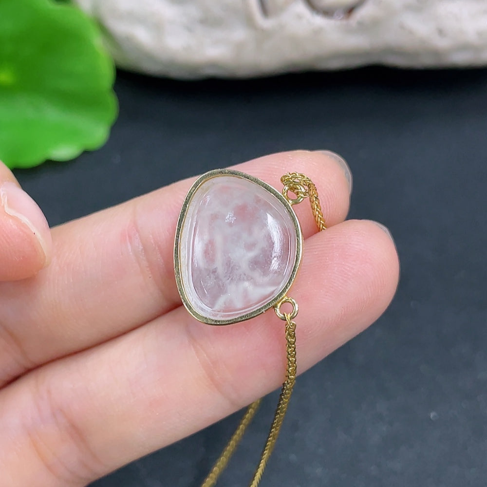 Jadeite pendant with 18K gold setting on a delicate chain, displayed against a neutral background showing fine craftsmanship.
