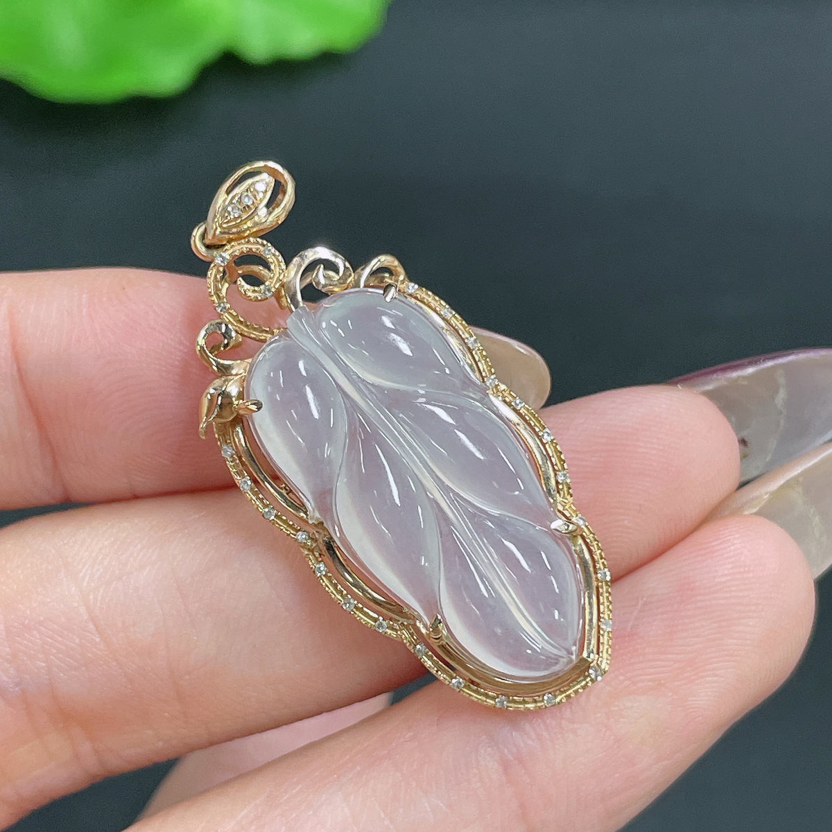 Jadeite leaf pendant with 18k gold inlay and diamond accents, crafted by HKHQ, weighing approximately 4.02 grams.