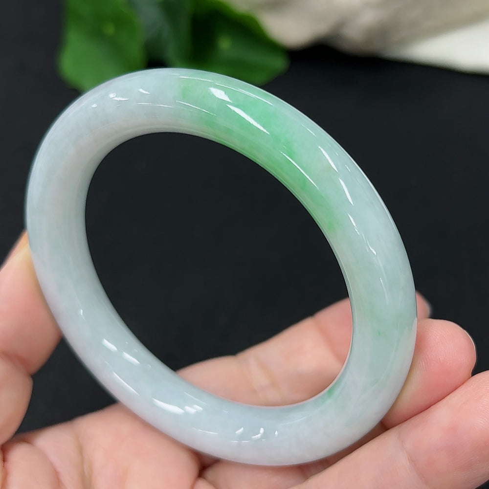 HKHQ jadeite round bangle in size 55, showcasing a smooth, polished surface and vibrant green color.