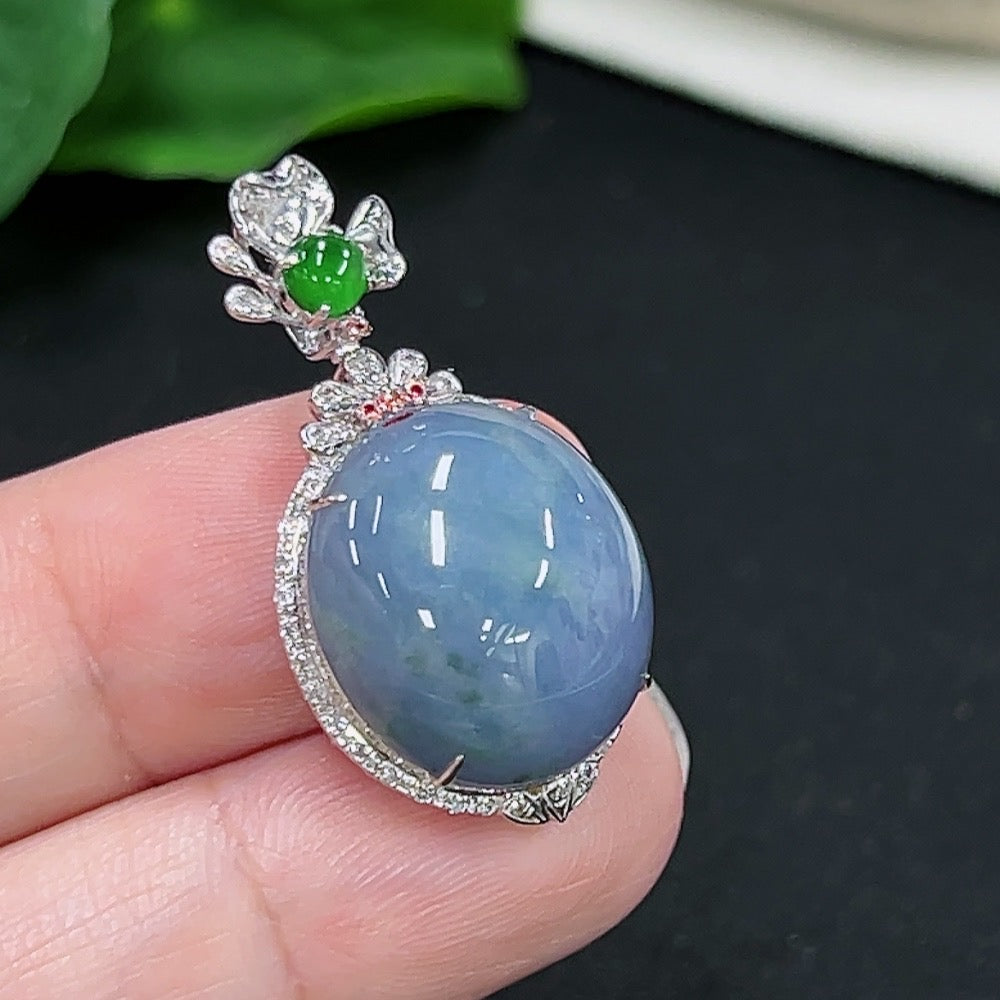 Jadeite cabochon pendant with 18k gold setting and four non-diamond accents, featuring a smooth, polished jade stone.