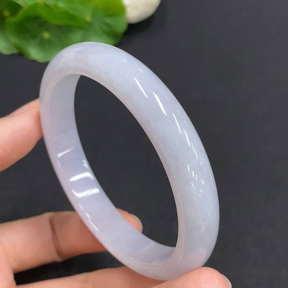 Huiliu certified jadeite round bangle, smooth polished jade jewelry with natural green hue, worn on a person's wrist