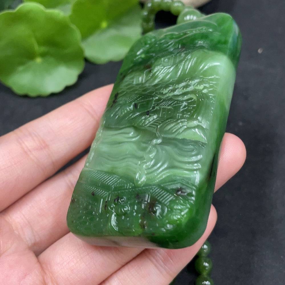 Huiliu certified Hetian jade pendant featuring Buddha observing the world, detailed jade craftsmanship and smooth polished finish.
