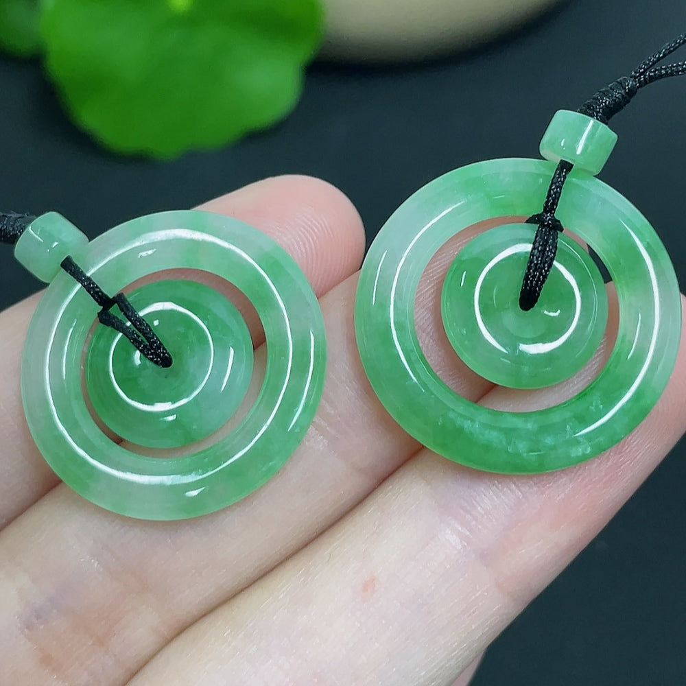 Jadeite pendant featuring mother-and-child buckle design on cord, weighing approximately 6.11g, by HKHQ.