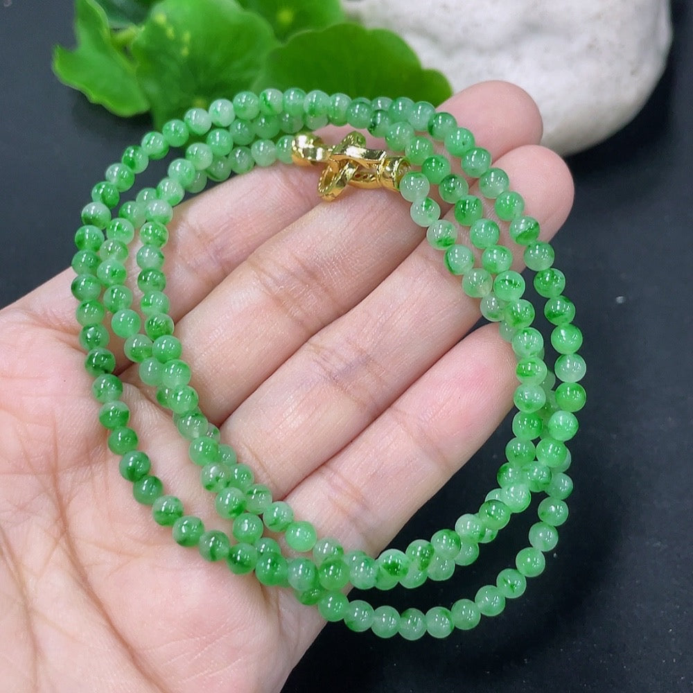 Jadeite bead necklace with natural mineral components, non-gold, featuring smooth, green jadeite beads on a delicate string.